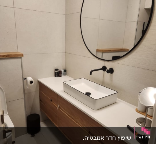 חדר אמבטיה עם כיור חדש ומראה עגולה